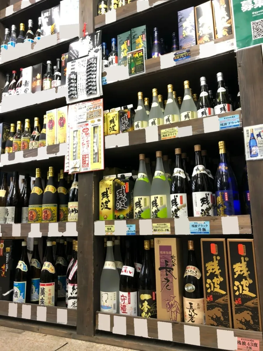 残波をはじめ、棚に並ぶ泡盛の一升瓶と紙パック