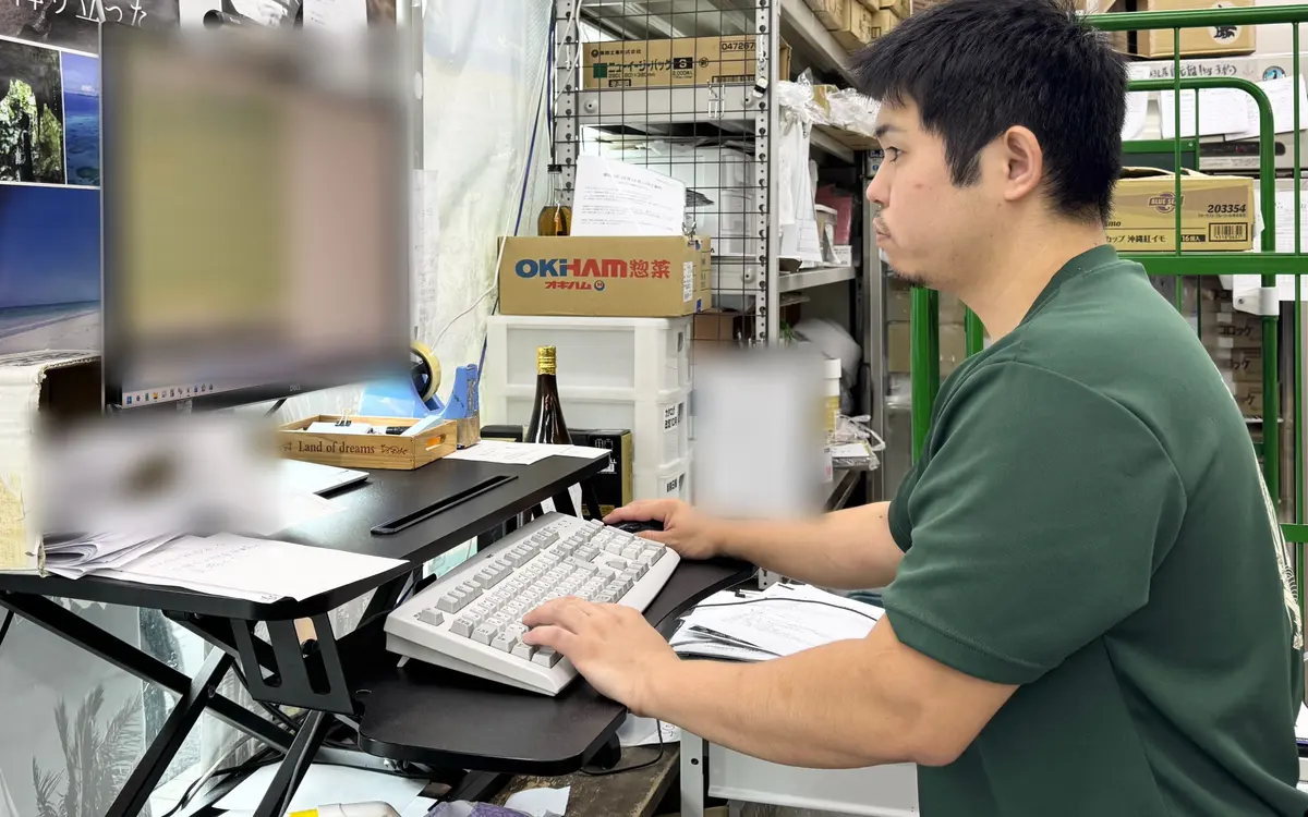 事務所のパソコンで作業する渕上さん
