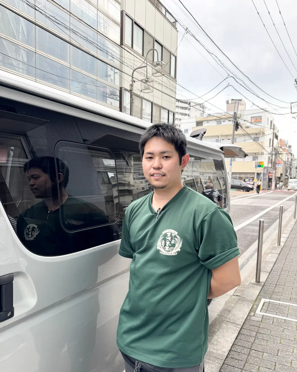 配送車の前に立つ、正社員の渕上さん